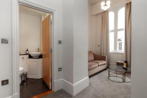 een woonkamer met een bank en een tafel bij Kensington House Hotel in Londen