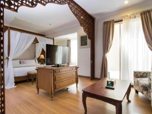 una camera da letto con un letto e una TV in una stanza di Horison Aziza Solo a Solo