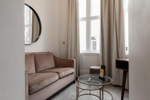 een woonkamer met een bank en een glazen tafel bij Kensington House Hotel in Londen