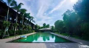 a swimming pool with a boat in the middle at The Buffalo Amphawa in Samut Songkhram