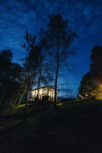 a lit up house in a field at night at Holiday cabin 'OAK' in Salacgrīva