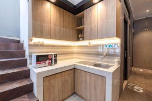 a small kitchen with a sink and a microwave at OYO Life 3246 Walnut Inn G-10 in Telukjambe