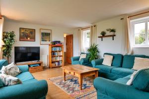 a living room with blue couches and a coffee table at Finest Retreats - Cricketers Cottage in Alderley