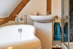 a bathroom with a sink and a tub and a toilet at Finest Retreats - Cricketers Cottage in Alderley +22 photos