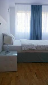 a bedroom with a bed and a table with a lamp at Apartment Zindan in Belgrade