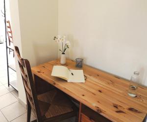 een houten tafel met een boek en bloemen erop bij Agapanthe blanche in La Garde +24 foto's