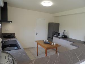 een keuken met een wastafel en een tafel. bij Agapanthe blanche in La Garde