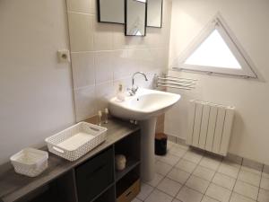 een badkamer met een wastafel en een raam bij Agapanthe blanche in La Garde