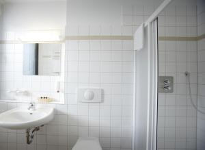 een witte badkamer met een wastafel en een douche bij Laerholz 84 in Bochum