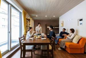 ミニョン マッペ في أوساكا: مجموعة من الأشخاص يجلسون حول طاولة في غرفة