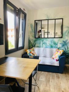 un salon avec un canapé bleu et une table dans l'établissement Appart'Hotel au Pradet, au Pradet