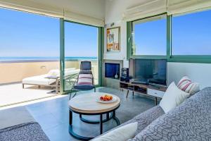 un soggiorno con un divano e un tavolo di Villa Cypressa by Villa Plus a Kalamitsi