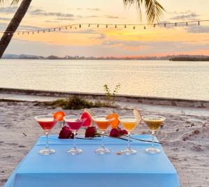 Una mesa con cuatro bebidas en la playa. en MNResort, en Koh Kong 19 fotos más