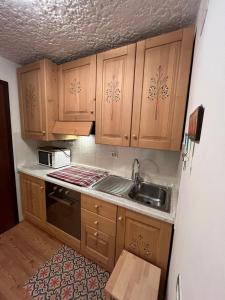 a kitchen with wooden cabinets and a sink at Casa Lilly in Folgarida