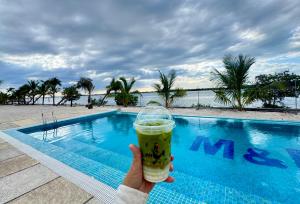 MNResort في كوه كونغ: شخص يحمل مشروب امام المسبح
