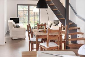 a dining room with a table and chairs and a staircase at Kembser Kate - Ostholstein - NEU! in Behrensdorf