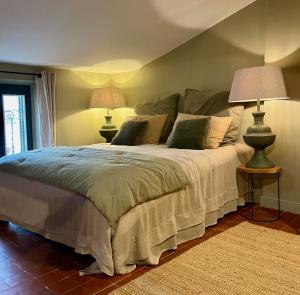 Le 215 Gambetta boutique hôtel en Provence في كافايو: غرفة نوم بسرير كبير مع مصباحين