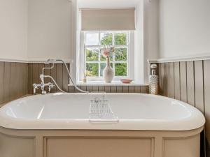 een wit bad in een badkamer met een raam bij 5 Bed in Machynlleth 92513 in Machynlleth +33 foto's