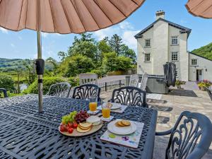 een tafel met een bord eten erop en een parasol bij 5 Bed in Machynlleth 92513 in Machynlleth