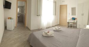 a white room with a bed with towels on it at Lampedusa Centro Camere&Appartamenti in LMP +51 photos