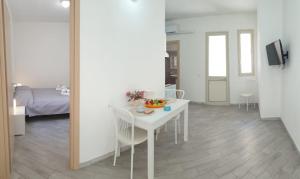 a white table and chairs in a room with a bedroom at Lampedusa Centro Camere&Appartamenti in LMP