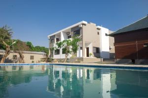 a swimming pool in front of a house at Vila Luísa Bilene in Vila Praia Do Bilene