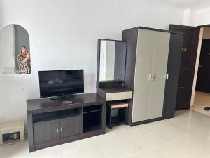 Happy Fish Guesthouse في شاطيء باتونغ: غرفة معيشة مع تلفزيون ومرآة