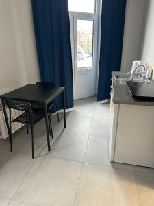 a black table and chair in a kitchen with a window at StarBal in Radom