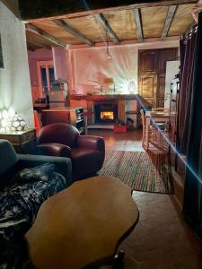 a living room with a table and a fireplace at Maison de village in Zevaco