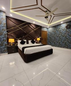 Tulip Capital Hotel في اسلام اباد: غرفة نوم بسرير كبير ومصباحين