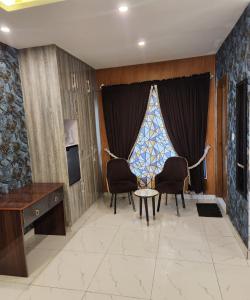 Tulip Capital Hotel في اسلام اباد: غرفة معيشة مع كراسي وطاولة ونافذة +47 صورة