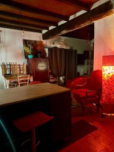 a living room with red chairs and a table at Maison de village in Zevaco
