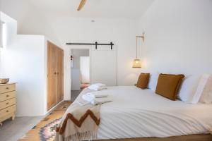 a bedroom with a large white bed with brown pillows at Casa Ladeira in Loulé +32 photos