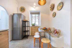 a kitchen with a table and a refrigerator at Casa Ladeira in Loulé