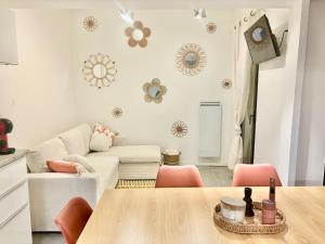 a living room with a table and pink chairs at Appartement 3 chambres - 8 couchages in Six-Fours-les-Plages