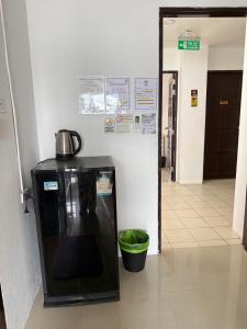 Happy Fish Guesthouse في شاطيء باتونغ: ثلاجة سوداء عليها غلاية في الردهة