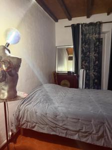 a bedroom with a bed and a lamp on a table at Maison de village in Zevaco