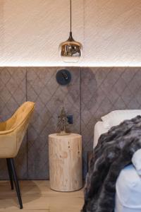 um quarto com uma cama, uma mesa e uma cadeira em Suite Chalet Stella Margherita em Passo San Pellegrino