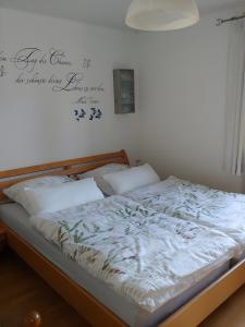 un letto in una stanza con un cartello sul muro di Ferienwohnung Dauth a Kressbronn am Bodensee