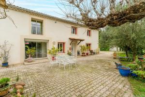 a patio with a table and chairs in front of a house at Chambre Bleuet in Piolenc
