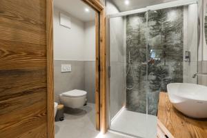a bathroom with a shower and a sink and a toilet at Suite Chalet Stella Margherita in Passo San Pellegrino