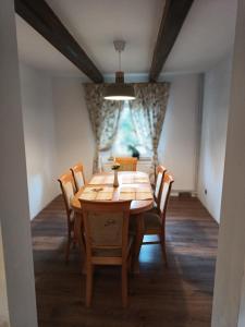 a dining room with a wooden table and chairs at Dom w górach Zacisze lasu in Sucha Beskidzka