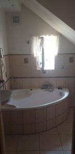 a large bath tub in a bathroom with a window at Dom w górach Zacisze lasu in Sucha Beskidzka