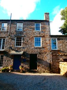 uma velha casa de pedra com uma porta azul em Riverside Bed & Breakfast em Bainbridge