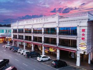 a large white building with cars parked in a parking lot at JC Mark Hotel in Bintulu