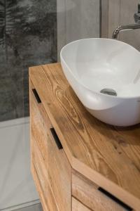 um lavatório branco num balcão de madeira na casa de banho em Suite Chalet Stella Margherita em Passo San Pellegrino