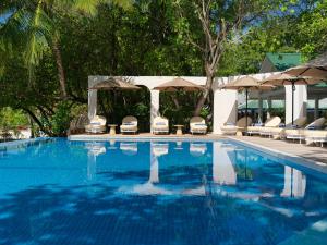 a swimming pool with chairs and umbrellas at Eri Maldives - 50 percent off on roundtrip speedboat valid for stays till 25th December 2025 in North Male Atoll