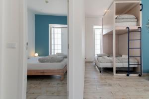 a bedroom with two bunk beds and blue walls at WOT Peniche Social in Peniche +76 photos