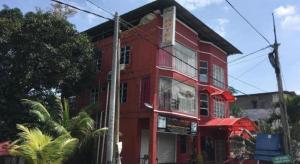 a red building on the corner of a street at OYO 89653 Anisaa Inn in Kampong Pengkalan Dopah