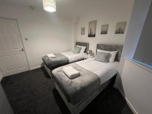 En eller flere senge i et værelse på Spacious 4-Bed Bungalow with Games Room & Parking